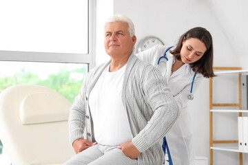 Obraz premium Female physiotherapist working with senior patient in rehabilitation center