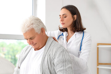 Obraz premium Female physiotherapist working with senior patient in rehabilitation center, closeup