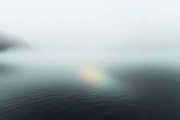 Fototapeta premium Shimmering mist envelops tranquil water with a faint rainbow at dawn