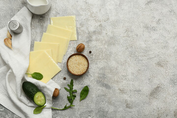 Slices of delicious processed cheese with fresh greens on grey grunge table