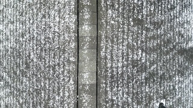 roof shingles and chimney view in winter (snow falling snowing snowy day) roofing of rural house with trees aerial footage looking down drone flying (close up home holidays wintertime) holiday travel