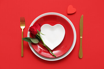 Beautiful table setting with red rose and heart on color background. Valentine's Day celebration