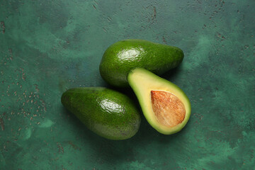 Fresh ripe avocados on green background