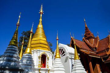 Fototapeta premium Chapel and Golden Pagoda, Lanna Architecture, Symbols of Buddhism, South East Asia at Doi Sapphanyu Temple, Mae Wang Chiangmai, Northern Thailand