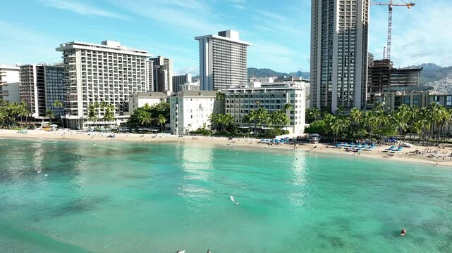 Drone Aerial View of Surfers and Waikiki Beach with Iconic Hotels in Hawaii