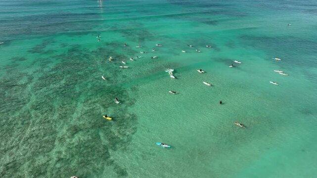 Drone Aerial View of Surfers Riding Waves in Hawaii Sea with Surfboards in the Blue transparent Ocean 
