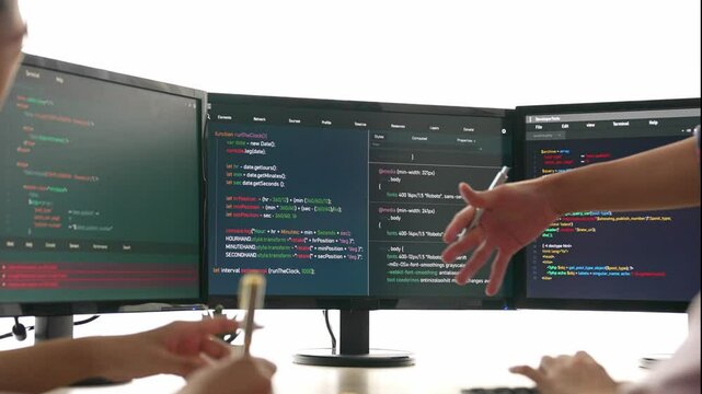 Slow motion back end software developer engineer for computer programming working together on debugging writing computing code, solving complex algorithms display on monitor in office. Burgeoning