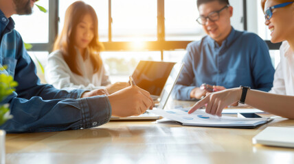 diverse team collaborating on project with enthusiasm and focus, using laptops and documents in bright office setting