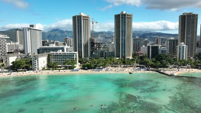 Drone Aerial View of Surfers and Waikiki Beach with Iconic Hotels in Hawaii