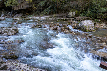 a stream of water in a stone riverbed, spewing noise and rumbling, making its way to free water