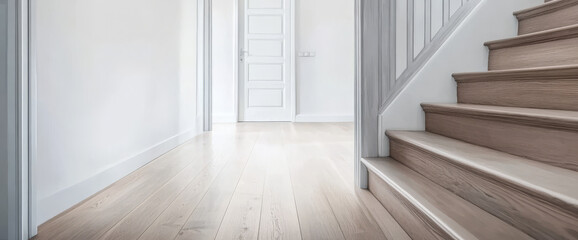 Obraz premium Modern hallway leads to a closed door beside a staircase in a bright interior space