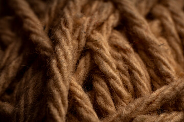 Creative weaving of natural brown yarn threads on textured fabric background ideal for textile designs