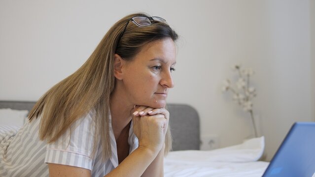 Woman works on laptop in bedroom deeply immersed in dreaming of innovative ideas and opportunities Her focus and creativity transform dreams into actionable plans showcasing power of dreams in work