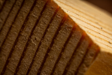 Close-up view of textured brown wood panel showing intricate patterns and natural markings