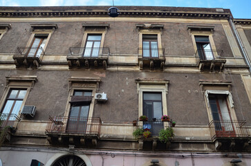 Characteristic Italian facades of tenement houses with balconies in Catania