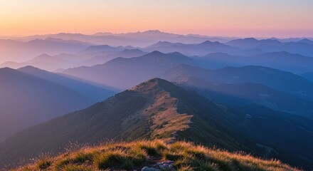 Obraz premium A serene mountaintop view with layers of blue ridges fading into the horizon illuminated by the soft light of dawn