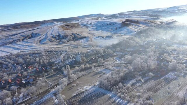 Aerial view of a misty countryside village, nature covered with hoarfrost