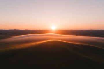 Soft hills bathed in golden sunlight create serene landscape at