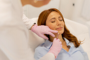 Fototapeta premium Expertly enhancing beauty through lip filler treatment in a serene clinic setting