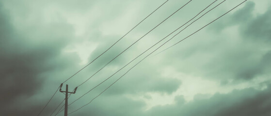 Fototapeta premium Wires interweaving with clouds under a gray sky symbolize exploration and movement