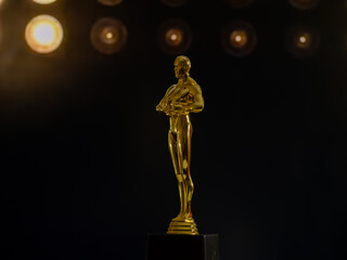 A golden Oscar statue stands on a black pedestal
