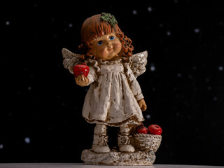 A small angel figurine holding an apple in its hand