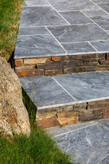 Petit jardin paysag&eacute; et ses plantes fleuries au pied d'une maison moderne.