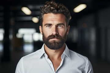 Obraz premium Portrait of confident businessman with stylish beard and hair posing in modern office