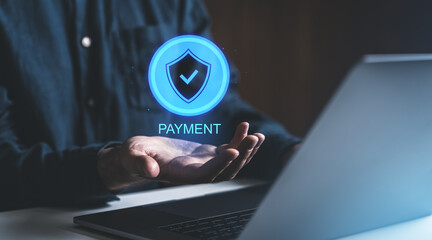 Digital payment security concept with shield icon hovering over a hand near laptop.