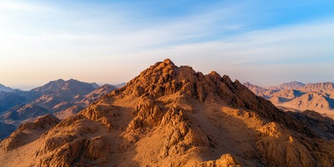 Fototapeta premium Aerial view topography composition concept. Majestic mountain peak bathed in golden sunlight with a vast desert landscape in the background.