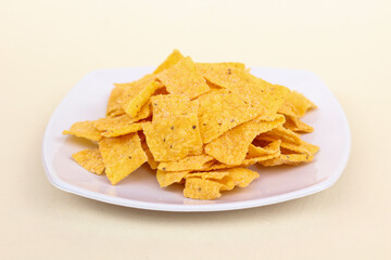 Close up of corn chips served in a plate and isolated on a white background.