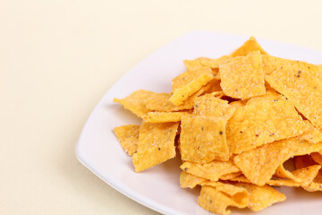 Close up of corn chips served in a plate and isolated on a white background.