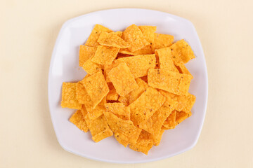 Close up of corn chips served in a plate and isolated on a white background.