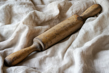 Classic wooden rolling pin resting on a soft linen fabric, evoking a sense of nostalgia for home baking and culinary traditions from a bygone era