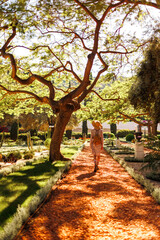 Obraz premium girl in motion expresses happiness in a city park. An attractive, cheerful woman feels free and joyful on a good day.