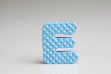  E alphabet in blue color foam on a white background