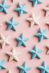 Obraz premium A vibrant arrangement of blue and white stars on a soft pink background, perfect for creative and festive themes.