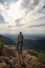 Obraz premium Woman with a backpack on her back on top of a mountain