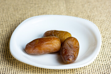 Fresh dates on a white plate. Ramadan concept.