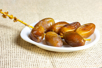Fresh dates on a white plate. Ramadan concept.