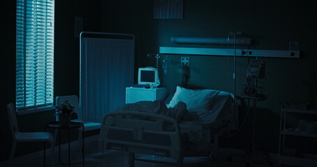 Empty hospital room with a bed and monitors.