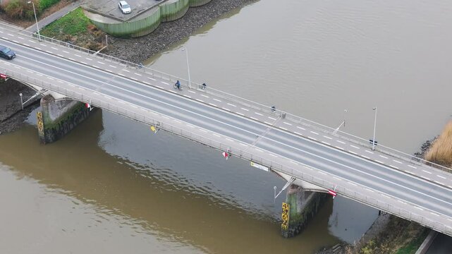 cars cyclist driving over bridge river below transportation modes area infrastructure forward aerial drone shot view perspective scenic overview 