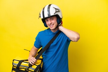 Young Brazilian man with thermal backpack isolated on yellow background laughing