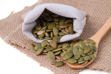 Pumpkin seeds. Raw pumpkin seeds on hemp sackcloth  and wood spoon