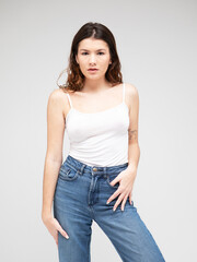 fashion model with long curly hair posing in studio over grey background