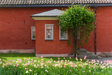 Flowers in from of red house