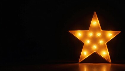 Golden star shaped light fixture, black background, illumination, celebration