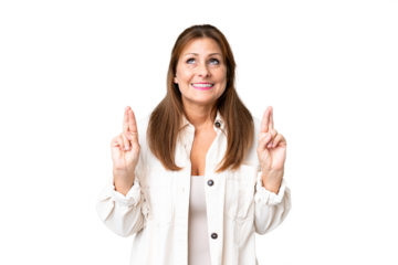 Middle age woman over isolated background with fingers crossing