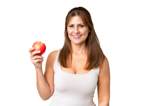 Middle age woman with an apple over isolated background smiling a lot