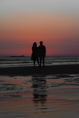 pareja de se&ntilde;ores de mediana edad viendo atardecer en la playa